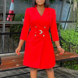 Detail of red blazer dress featuring pleated asymmetric hem and silver buttons