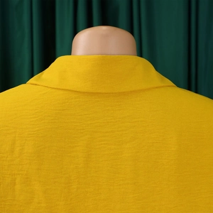 Macro shot of bright yellow lapel collar and textured fabric detail on a summer shirt