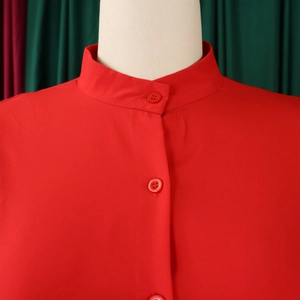 Detail of red stand-up collar dress with matching resin buttons and fine stitching