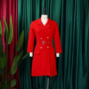 Detail of red double-breasted blazer dress with pleated hem and waist belt on mannequin
