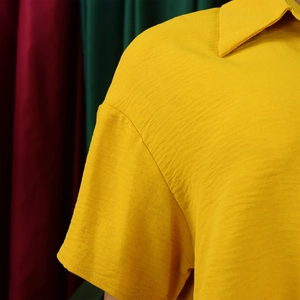 Detailed view of yellow lapel shirt featuring high-quality textured crinkle fabric