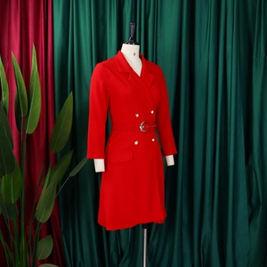 Detail of red blazer dress featuring peak lapels and metallic double-breasted buttons
