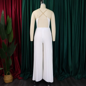 Detail of white pleated wide-leg jumpsuit featuring metallic gold chain straps and open back