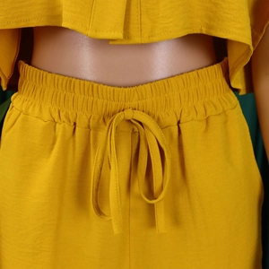 Detailed view of yellow two-piece set featuring elastic drawstring waist and textured fabric