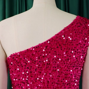 Detail of sequined magenta one-shoulder gown showing neckline cut and fabric texture