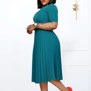 Detail view of the pleated hem and waistline of a dark green short sleeve midi dress