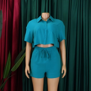 Detail view of teal short sleeve crop shirt with collar and matching drawstring shorts