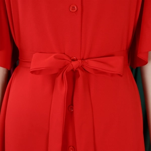 Detail of red shirt dress waist featuring neat buttons and a stylish bow tie belt