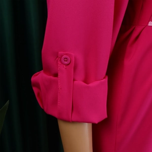 Detailed macro view of the rose red shirt sleeve with adjustable buttoned tab and cuffs