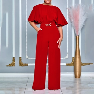 Detail of red wide-leg jumpsuit featuring batwing sleeves and rhinestone waist buckle