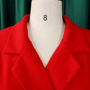 Close-up of vibrant red blazer lapel with textured fabric on a beige mannequin