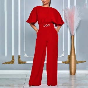 Detailed shot of red jumpsuit featuring flutter sleeves and a gold chain buckle belt
