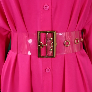 Close-up of bright pink shirt dress featuring a clear PVC belt with gold metal buckle