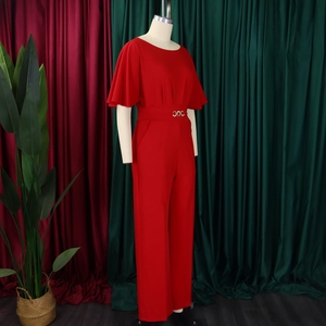 Detail of red high-waist jumpsuit with elegant golden double-ring buckle and wide leg cut
