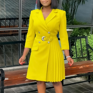 Detail of yellow blazer dress with double-breasted buttons and pleated skirt side