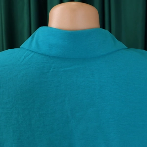 Close-up of lapel collar and back detail on turquoise casual shirt with fine fabric texture