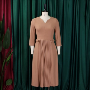 Detail of khaki pleated dress with three-quarter sleeves and V-neckline on a mannequin
