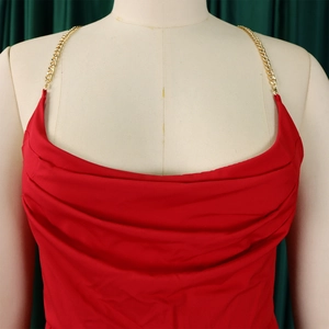 Detail of red jumpsuit with gold chain straps and elegant cowl neck design