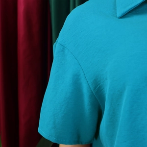 Detail of blue lapel collar and shoulder stitching on a casual short sleeve shirt