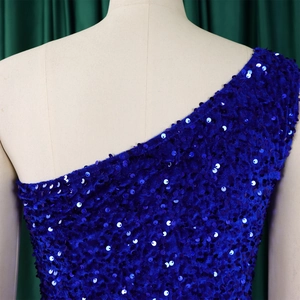 Detail of royal blue sequins on an asymmetric one-shoulder evening gown with velvet base