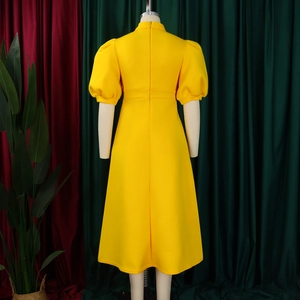 Back view of a bright yellow puff sleeve dress with a hidden zipper and flared A-line skirt