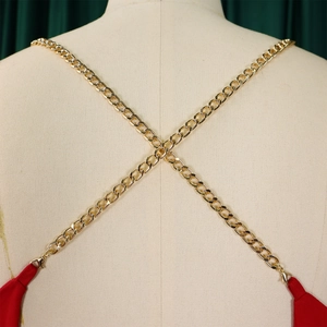 Detail of elegant gold metal chain straps on the back of a red halter jumpsuit