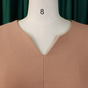 Close-up of V-neckline detail on mauve pleated dress featuring crinkle texture fabric
