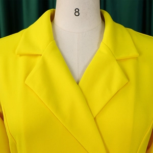 Detail of bright yellow pleated blazer dress with wide lapels on a size 8 mannequin