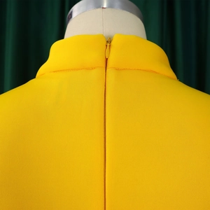 Detail of yellow high neck dress showing seamless invisible zipper and fabric texture