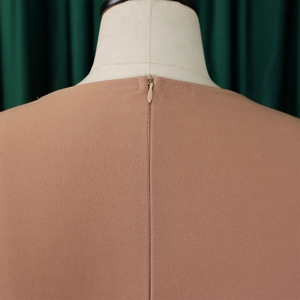 Detailed view of invisible back zipper closure on dusty pink crepe fabric dress
