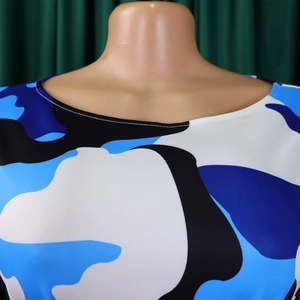 Détail de l'encolure ronde et de l'imprimé camouflage bleu sur une robe en maille