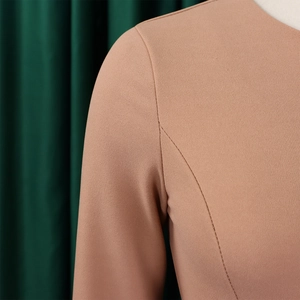 Close-up of pleated sleeves on a dusty pink dress with fine textured fabric details