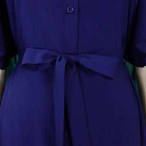 Detail of navy blue summer dress featuring a belted waist with a neat bow and buttons