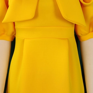 Detailed view of yellow party dress with waist stitching and pleated skirt texture