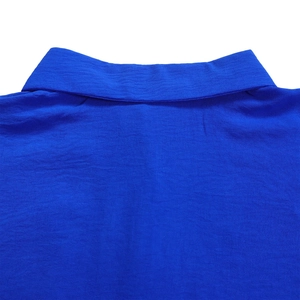 Detail shot of royal blue knit polo shirt collar with premium textured fabric finish