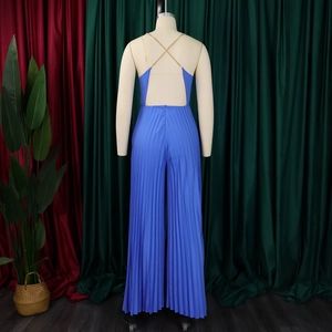 Detail of royal blue pleated jumpsuit featuring open back and gold chain straps