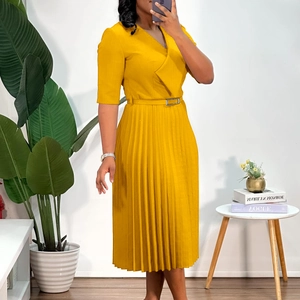 Détail d'une robe mi-longue plissée jaune moutarde avec col en V et ceinture élégante