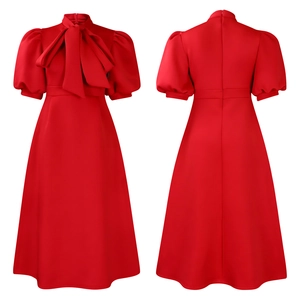 Detail of a bright red dress featuring a large neckline bow and puffed short sleeves