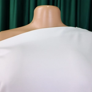 Detailansicht des weißen asymmetrischen One-Shoulder-Tops mit feiner Gewebetextur