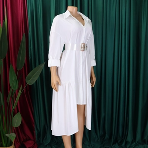Detail of white shirt dress featuring asymmetrical hem and transparent PVC belt with gold buckle