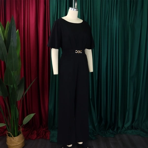Detail of black wide-leg jumpsuit with short sleeves and gold circular waist buckle