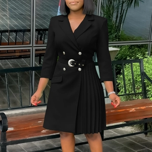 Detail of black double-breasted blazer dress with waist belt and pleated patchwork hem