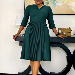 Detail of V-neck dark green pleated dress featuring three-quarter sleeves and A-line silhouette