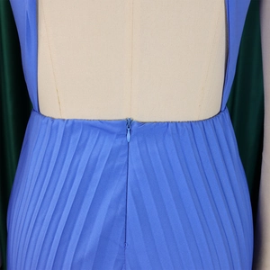 Detail of blue pleated jumpsuit back showing invisible zipper and premium fabric texture