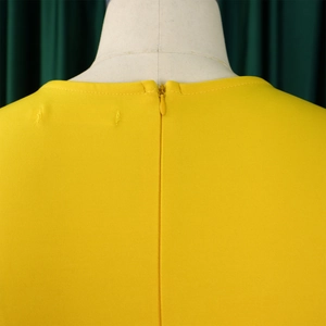 Macro view of bright yellow party dress featuring a back invisible zipper and round neckline