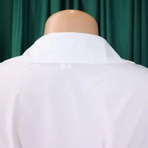 Detail of white button-down shirt collar and back view on mannequin with green background