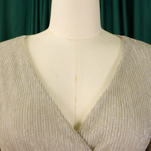 Detail of elegant V-neck champagne gold pleated fabric with metallic luster on mannequin