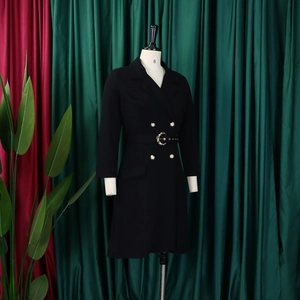 Detail of black double-breasted blazer dress with metal buttons and buckled waist belt