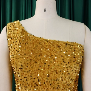 Detailed close-up of golden sequins on one-shoulder velvet evening gown for women