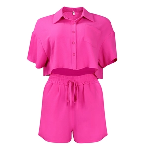 Detail of rose pink two-piece set featuring short sleeve shirt with chest pocket and shorts